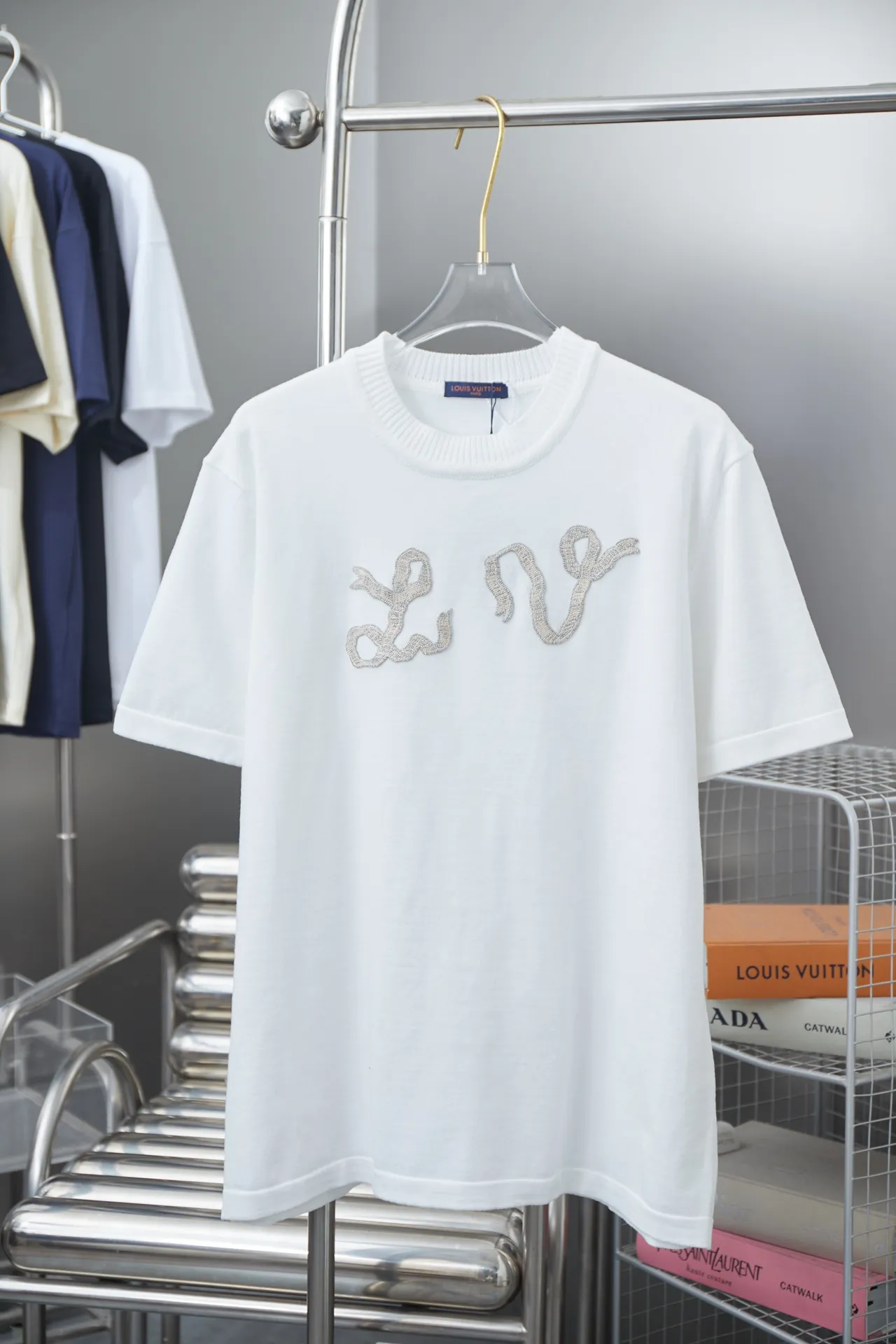 🅿️200 Louis LV 25ss early spring new short-sleeved pearl yarn chapter knitted short-sleeved light luxury essential item for daily commuting for men and women Correct version Welcome to compare Detailed features · High-viscosity cotton material wool, high-count cotton added, dry and avoid stuffiness · The embroidery process forms patterns on the surface of knitted fabrics, and uses different colors and different types of yarns to weave into independent solid color areas. The color blocks are connected to form patterns without floating lines, with perfect edges. Paired with knitting of the same style and color, it presents a unique three-dimensional texture · Double-needle stitching and cross-stitching process · Original main mark washed tag brand moisture-proof paper packaging Color: White Size: S/M/L/XL
